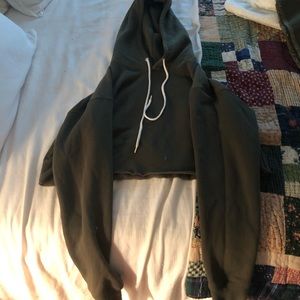 Cropped long sleeve dark green hooded sweatshirt.